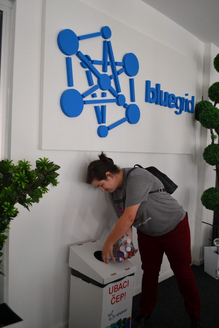 A woman is adding caps to the box.
