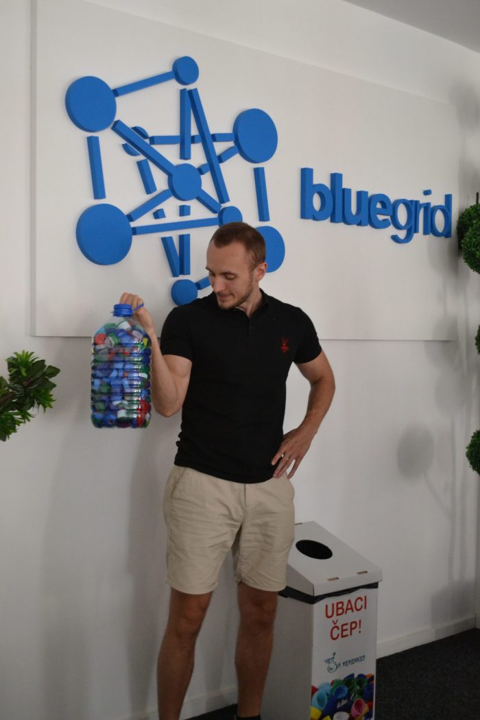 A man is holding a plastic water balloon filled with bottle caps.