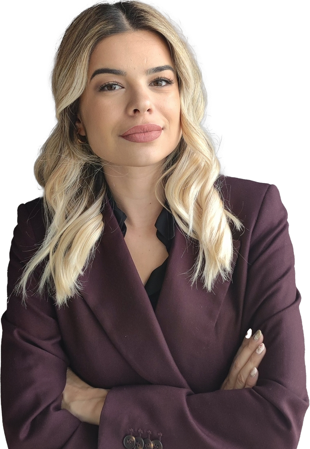 A smiling woman in a red suit, posing with her arms crossed.