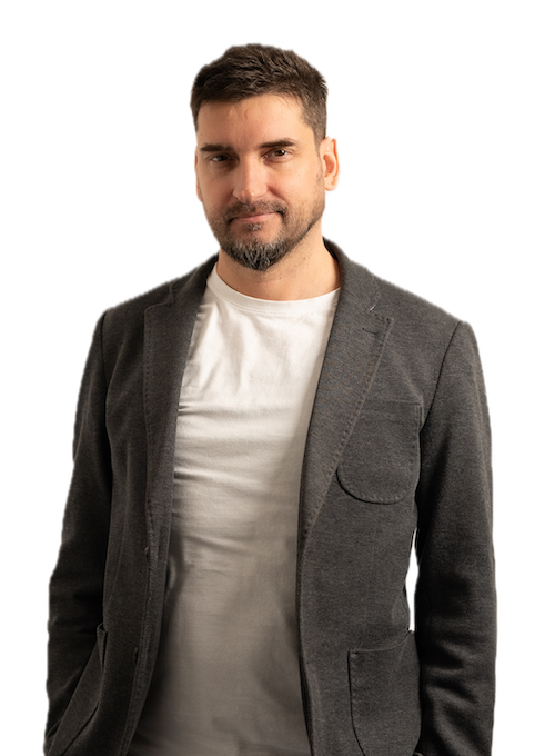 A photo of the author standing with his hands in his pockets, wearing a grey blazer.